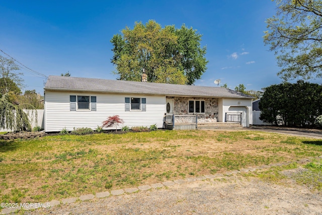 ranch-style house featuring an attached garage, aphalt driveway, and a porch