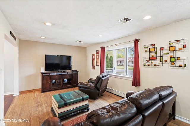 living room with recessed lighting, a baseboard radiator, light wood-style flooring, and baseboards