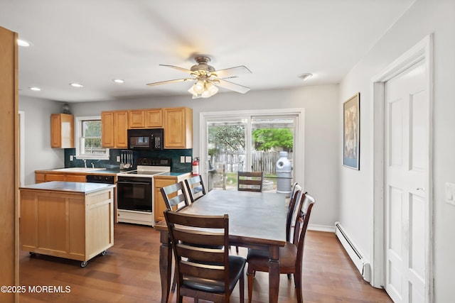 dining space with recessed lighting, a baseboard radiator, dark wood finished floors, and plenty of natural light
