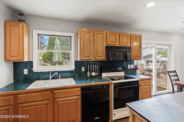 kitchen featuring decorative backsplash, a sink, black appliances, and plenty of natural light