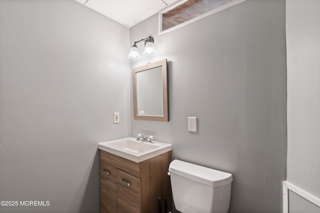 half bathroom with vanity and toilet