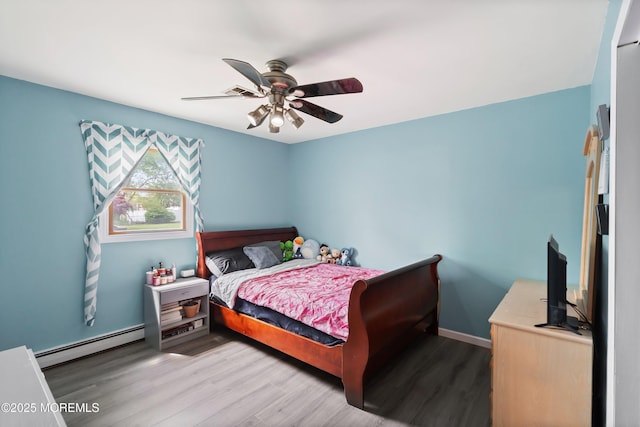 bedroom featuring baseboards, baseboard heating, a ceiling fan, and wood finished floors