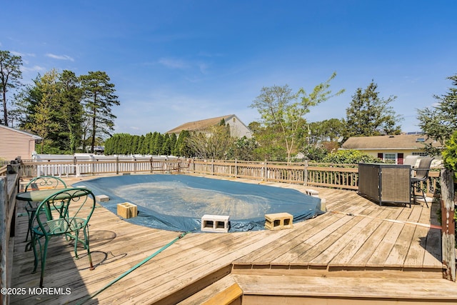 view of swimming pool with a wooden deck, grilling area, and outdoor dining space