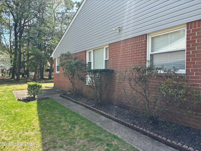 view of property exterior featuring a yard and brick siding