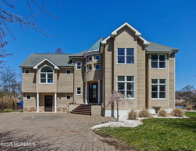 view of front facade with a front lawn and decorative driveway