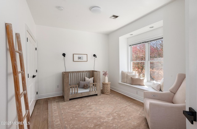 bedroom featuring visible vents, wood finished floors, and baseboards