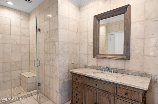 bathroom with vanity, a shower stall, recessed lighting, and tile walls