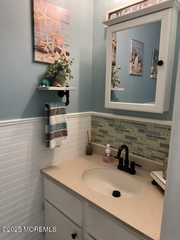 bathroom with vanity and a wainscoted wall