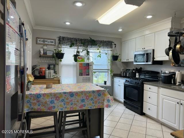 kitchen with crown molding, light tile patterned floors, white cabinets, and stainless steel appliances