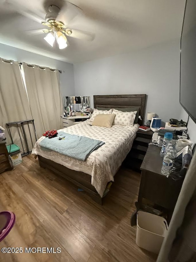 bedroom with ceiling fan and dark wood-type flooring