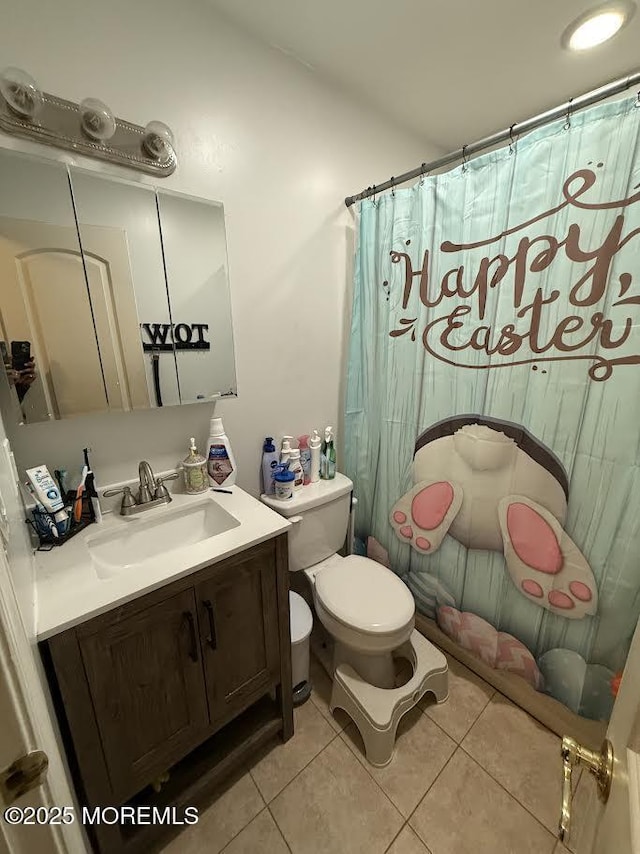 bathroom featuring vanity, a shower with shower curtain, tile patterned floors, and toilet