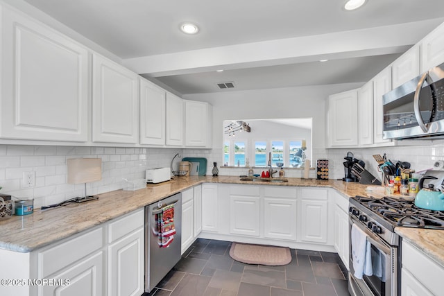 405 Sunset Dr S, Berkeley, NJ 08721 - kitchen featuring white cabinetry, stainless steel appliances, decorative backsplash, and visible vents