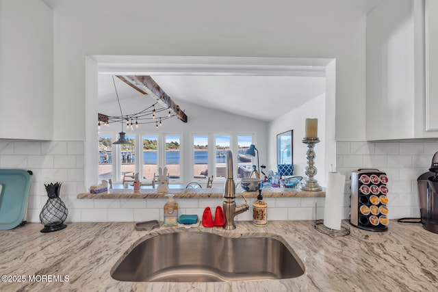 405 Sunset Dr S, Berkeley, NJ 08721 - kitchen featuring a sink, vaulted ceiling with beams, white cabinets, backsplash, and light stone counters