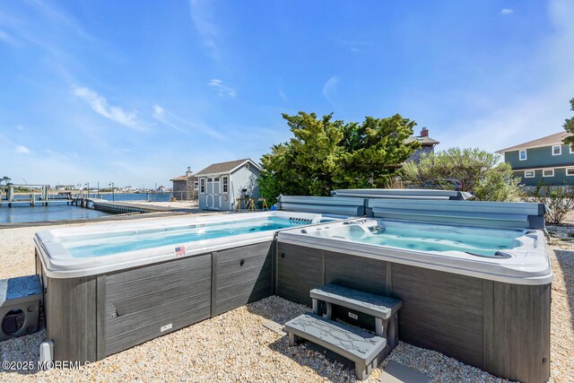 405 Sunset Dr S, Berkeley, NJ 08721 - view of pool with a hot tub, a water view, and an outbuilding