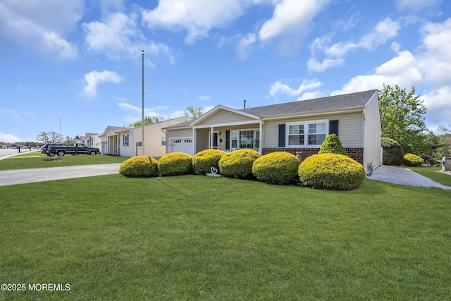 ranch-style home featuring brick siding, a garage, a front lawn, and driveway