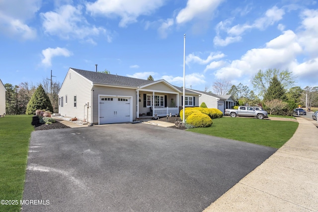 view of front of home featuring covered porch, an attached garage, driveway, and a front lawn