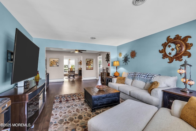 living area featuring visible vents, baseboards, ceiling fan, and wood finished floors