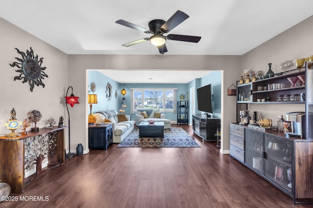 living room featuring baseboards, a ceiling fan, and dark wood finished floors