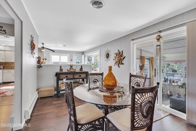 dining space featuring ceiling fan, dark wood finished floors, visible vents, and a baseboard radiator