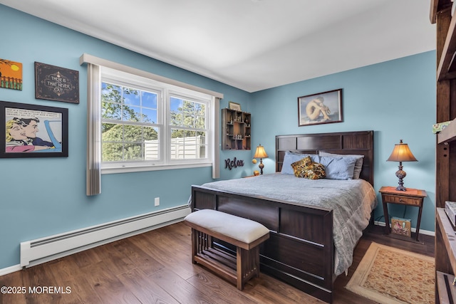 bedroom with baseboards, a baseboard heating unit, and wood finished floors