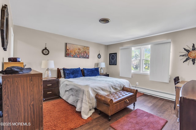 bedroom featuring visible vents, wood finished floors, and baseboard heating