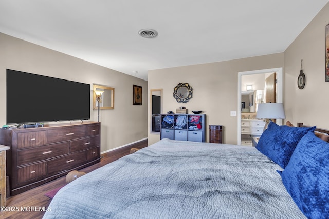 bedroom featuring visible vents, connected bathroom, dark wood finished floors, and baseboards
