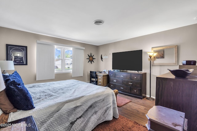 bedroom with visible vents and wood finished floors