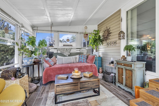 sunroom / solarium featuring wood finish floors, outdoor lounge area, and vaulted ceiling with beams