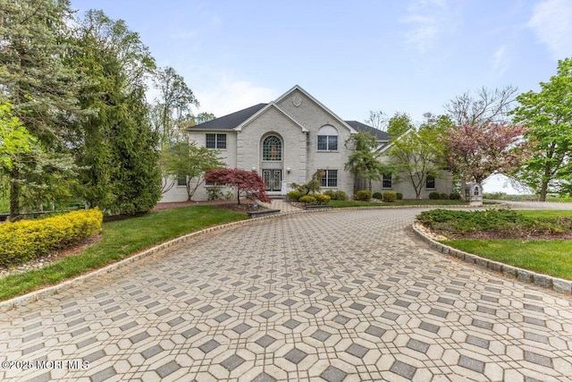 view of front of house with curved driveway and brick siding