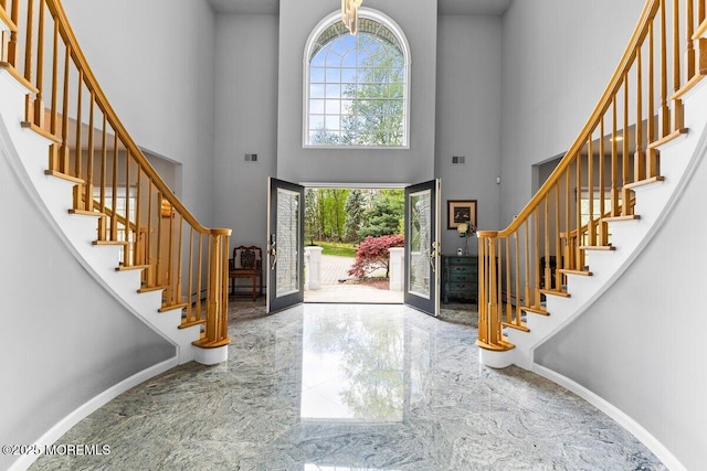 entryway with visible vents, marble finish floor, a towering ceiling, and stairway