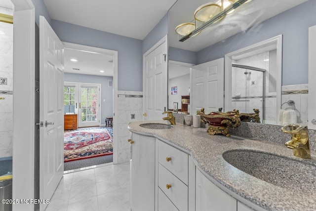 ensuite bathroom with a sink, a shower stall, marble finish floor, and connected bathroom