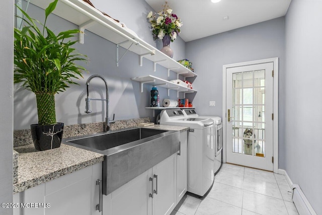 laundry room with a sink, baseboards, washing machine and dryer, and cabinet space