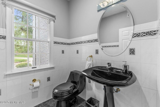 half bathroom with toilet and tile walls