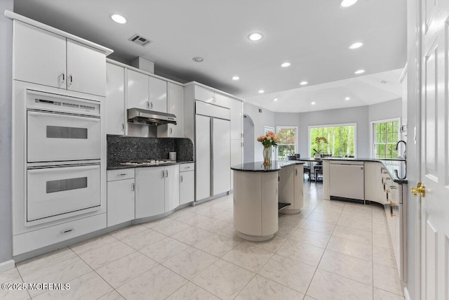 kitchen with stainless steel gas cooktop, recessed lighting, under cabinet range hood, white double oven, and dishwasher