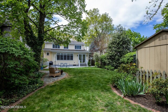 back of house with a lawn, entry steps, fence, and a patio