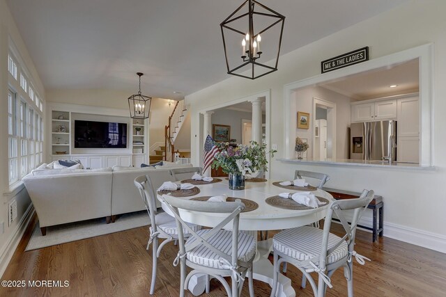 dining room with stairs, wood finished floors, and a chandelier