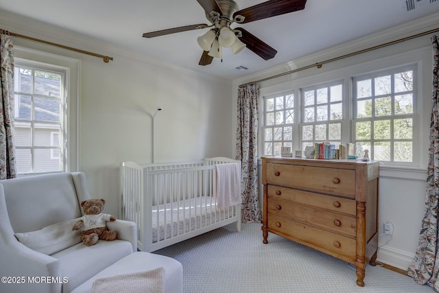 bedroom with carpet floors, ornamental molding, a crib, and multiple windows