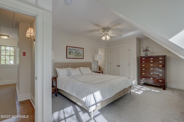 bedroom featuring a closet, baseboards, ceiling fan, and attic access