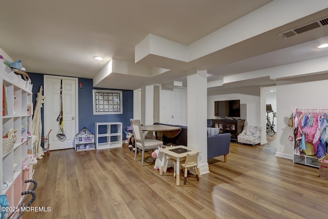 playroom featuring baseboards, visible vents, and wood finished floors