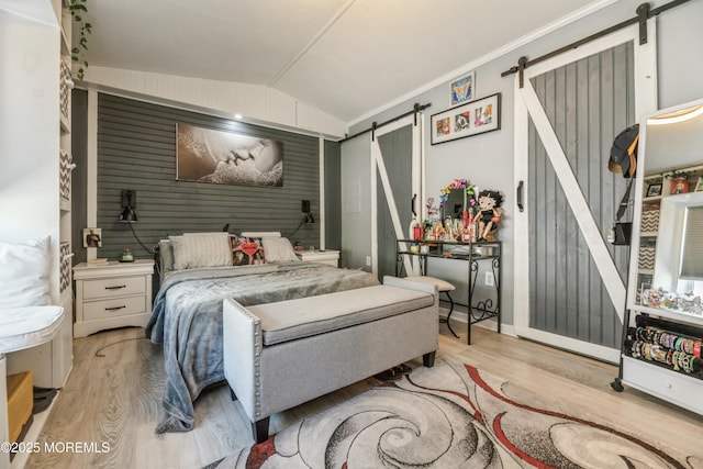 501 Ln F, Hazlet, NJ 07730 - bedroom featuring lofted ceiling, wood finished floors, an accent wall, wooden walls, and a barn door