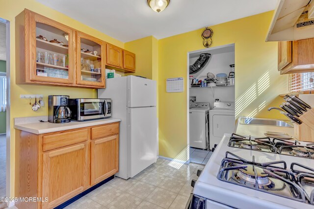 957 Harrison Rd, Toms River, NJ 08753 - kitchen featuring separate washer and dryer, white appliances, under cabinet range hood, a sink, and light countertops