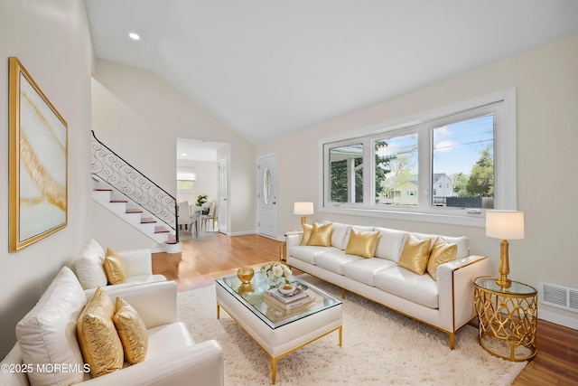 12 Mayfair Rd, Holmdel, NJ 07733 - living room with lofted ceiling, wood finished floors, visible vents, and stairway