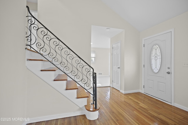 12 Mayfair Rd, Holmdel, NJ 07733 - foyer entrance with baseboards, hardwood / wood-style flooring, stairs, and vaulted ceiling