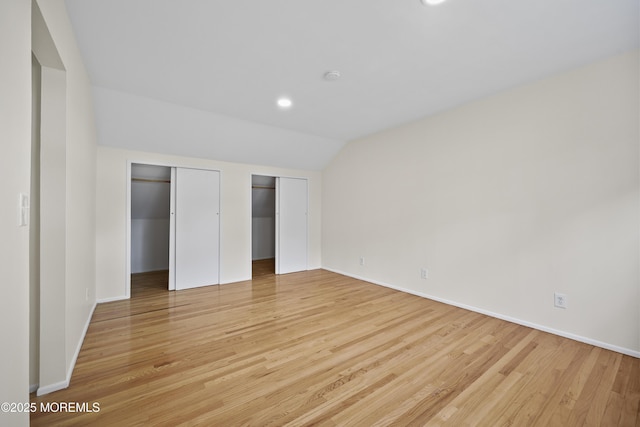 12 Mayfair Rd, Holmdel, NJ 07733 - unfurnished bedroom featuring multiple closets, light wood finished floors, vaulted ceiling, and baseboards