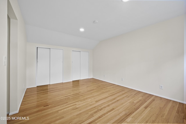 12 Mayfair Rd, Holmdel, NJ 07733 - unfurnished bedroom with baseboards, light wood-style flooring, lofted ceiling, and multiple closets