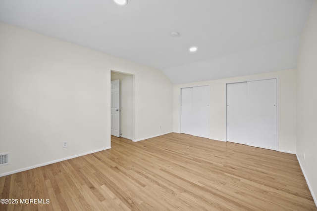 12 Mayfair Rd, Holmdel, NJ 07733 - unfurnished bedroom with light wood-style flooring, two closets, baseboards, visible vents, and lofted ceiling