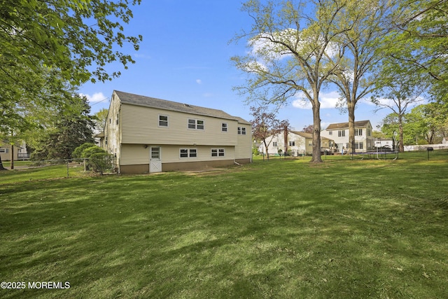 12 Mayfair Rd, Holmdel, NJ 07733 - rear view of house featuring a yard, a trampoline, and fence
