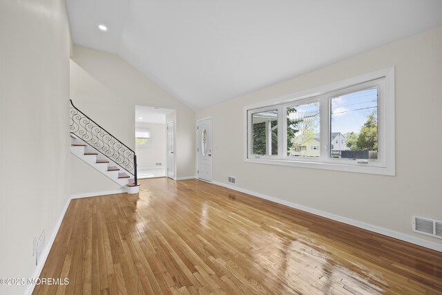 12 Mayfair Rd, Holmdel, NJ 07733 - unfurnished living room with visible vents, stairway, lofted ceiling, and light wood-style flooring