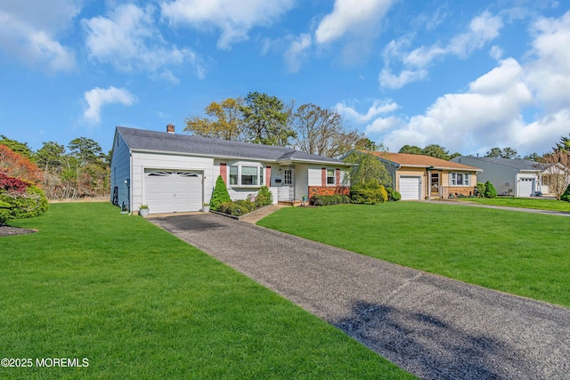 ranch-style home with a garage, a chimney, driveway, and a front yard
