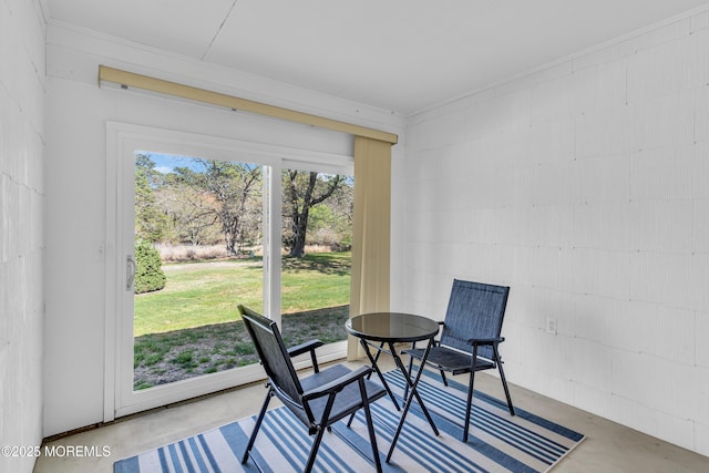 dining area with concrete flooring and concrete block wall